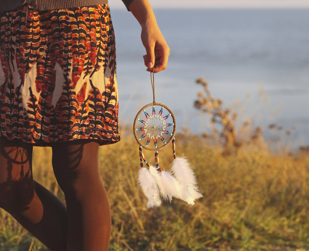 Brunette woman with long hair holding dream catcher in her hands